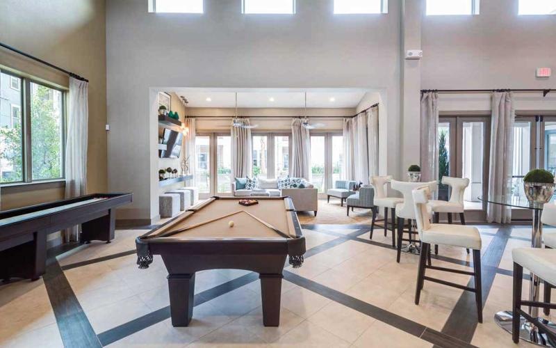 a room with a pool table and chairs